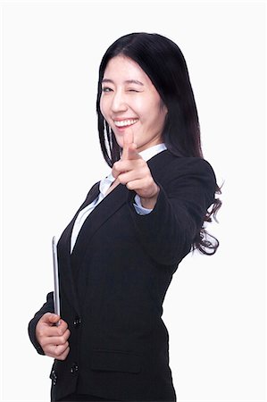 Businesswoman pointing finger like gun Stock Photo - Premium Royalty-Free, Code: 6116-07086338