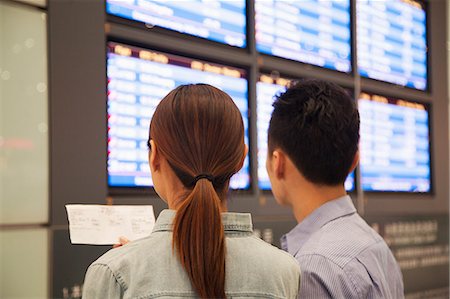simsearch:6116-07086481,k - Two travelers looking at flight departure screens at airport Stock Photo - Premium Royalty-Free, Code: 6116-07086489