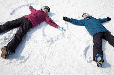 smile snowboard - Man and Woman Lying on the Snow Making Snow Angel Stock Photo - Premium Royalty-Free, Code: 6116-07086608