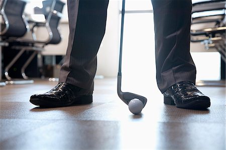 simsearch:6116-07086775,k - Businessman playing golf in his office, close up on feet Photographie de stock - Premium Libres de Droits, Code: 6116-07086746