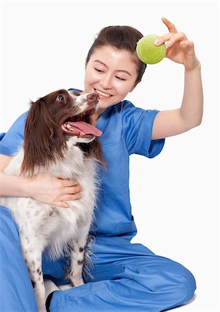person and dog and play and happy - Portrait of female veterinarian holding a ball with a dog Stock Photo - Premium Royalty-Free, Code: 6116-07086700