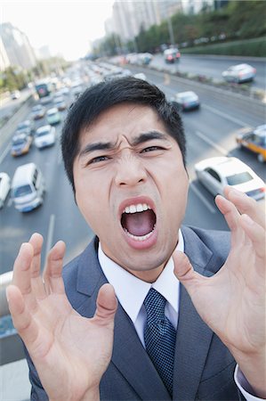 simsearch:6116-07235392,k - Young Angry Businessman Yelling Over Freeway Foto de stock - Royalty Free Premium, Número: 6116-07235386