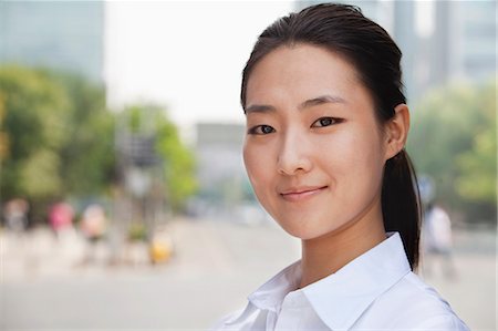 Portrait of young businesswoman smiling outside in Beijing Stock Photo - Premium Royalty-Free, Code: 6116-07235313