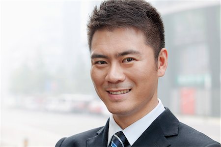 simsearch:6116-07235392,k - Young Businessman Smiling and Looking into Camera, Portrait Foto de stock - Royalty Free Premium, Número: 6116-07235440