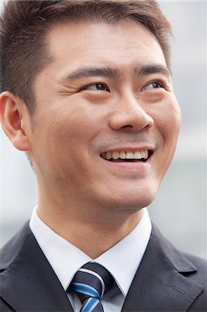 simsearch:6116-06938507,k - Young Businessman Smiling and Looking Away, Portrait Stockbilder - Premium RF Lizenzfrei, Bildnummer: 6116-07235433