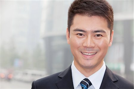 simsearch:6116-07235392,k - Young Businessman Smiling and Looking into Camera, Portrait Foto de stock - Royalty Free Premium, Número: 6116-07235437