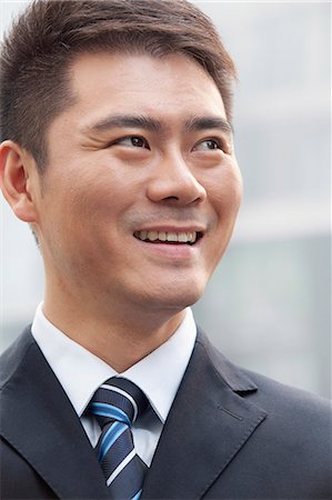 simsearch:6116-07235392,k - Young Businessman Smiling and Looking Away, Portrait Foto de stock - Royalty Free Premium, Número: 6116-07235434
