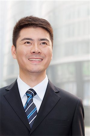 simsearch:6116-07235392,k - Young Businessman Smiling and Looking Up, Portrait Foto de stock - Royalty Free Premium, Número: 6116-07235436
