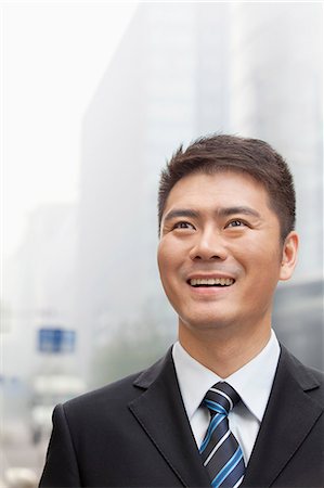 simsearch:6116-07235740,k - Young Businessman Smiling and Looking into the Distance, Portrait Stockbilder - Premium RF Lizenzfrei, Bildnummer: 6116-07235439