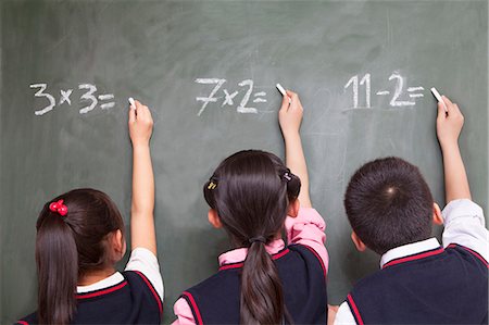 Three school children doing math equations on the blackboard Photographie de stock - Premium Libres de Droits, Code: 6116-07235687