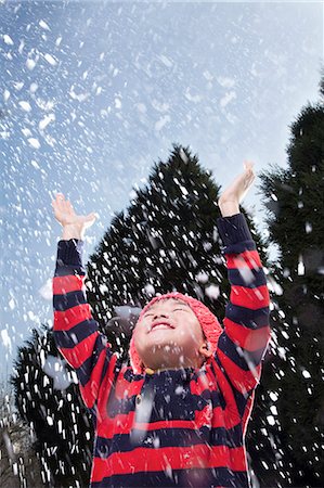 Boy with arms raised feeling the snow Fotografie stock - Premium Royalty-Free, Codice: 6116-07235699