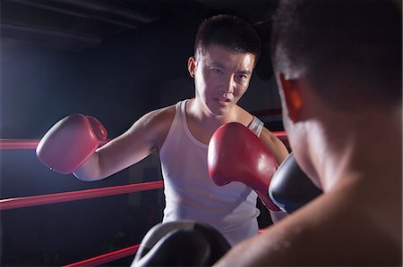 Over the shoulder view of two male boxers fighting in the boxing ring in Beijing, China Photographie de stock - Premium Libres de Droits, Code: 6116-07235777