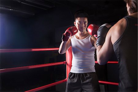 rivaux - Over the shoulder view of two male boxers getting ready to box in the boxing ring in Beijing, China Photographie de stock - Premium Libres de Droits, Code: 6116-07235776