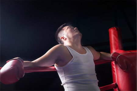 simsearch:6116-07235773,k - Tired boxer resting on the ropes in boxing ring, looking up Photographie de stock - Premium Libres de Droits, Code: 6116-07235778