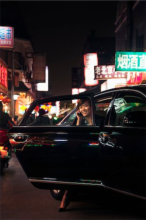 single traveling female - Businesswoman exiting car while on the phone, Beijing at nighttime Foto de stock - Sin royalties Premium, Código: 6116-07235795