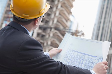 suit man standing backside - Architect on site looking at blueprints Stock Photo - Premium Royalty-Free, Code: 6116-07235731