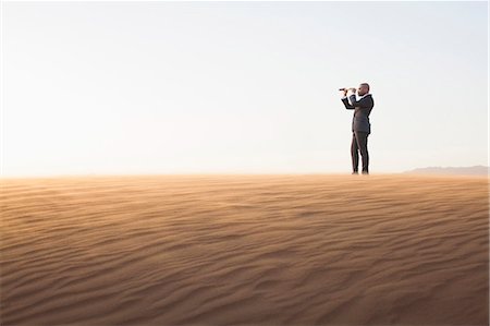 distanz (entfernung) - Young businessman looking through telescope in  the middle of the desert Stockbilder - Premium RF Lizenzfrei, Bildnummer: 6116-07235945