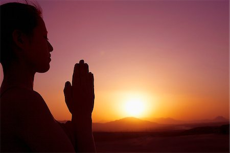 simsearch:6116-07235975,k - Serene young woman with hands together in prayer pose  in the desert in China, silhouette, sun setting, profile Foto de stock - Sin royalties Premium, Código: 6116-07235951