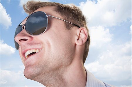 sunglasses on head - Portrait of young businessman in sunglasses smiling, close-up on face Stock Photo - Premium Royalty-Free, Code: 6116-07235977