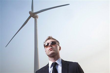 suit man asian - Portrait of serious young businessman in sunglasses standing by a wind turbine Foto de stock - Sin royalties Premium, Código: 6116-07235979