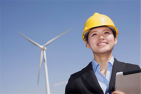 environmental issues for computers - Young smiling female engineer checking wind turbines on site Stock Photo - Premium Royalty-Free, Code: 6116-07235937