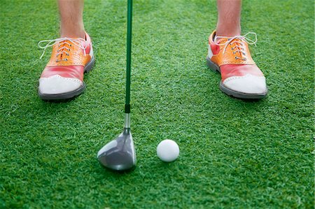 Close up on feet and golf club getting ready to hit a golf ball Stock Photo - Premium Royalty-Free, Code: 6116-07236045