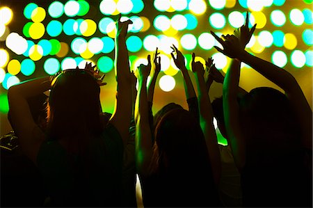 Audience watching a rock show, hands in the air, rear view, stage lights Photographie de stock - Premium Libres de Droits, Code: 6116-07236051