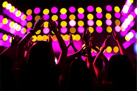 dancing concert - Audience watching a rock show, hands in the air, rear view, stage lights Stock Photo - Premium Royalty-Free, Code: 6116-07236052