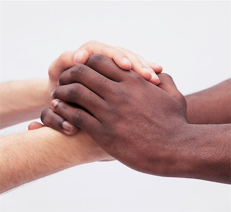 Two young men clasping each others hands, close-up, studio shot Stock Photo - Premium Royalty-Free, Code: 6116-07236003