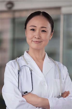 Portrait of female doctor with arms crossed outside of the hospital Foto de stock - Sin royalties Premium, Código: 6116-07236173