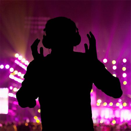 simsearch:649-08576877,k - Silhouette of DJ wearing headphones and performing at a night club Stock Photo - Premium Royalty-Free, Code: 6116-07236255