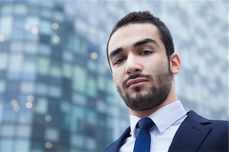 simsearch:6116-07235392,k - Portrait of serious young businessman, outdoors, business district Foto de stock - Royalty Free Premium, Número: 6116-07236282