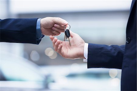 simsearch:6116-07086775,k - Car salesman handing over the keys for a new car to a young businessman, close-up Photographie de stock - Premium Libres de Droits, Code: 6116-07236287