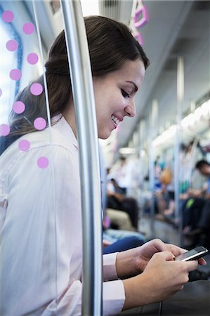 simsearch:6108-06166967,k - Young businesswoman sitting on the subway and using her phone Stock Photo - Premium Royalty-Free, Code: 6116-07236294