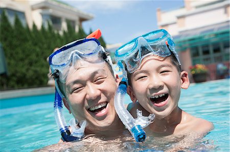 father holding son in pool - Portrait of father and son with snorkeling equipment in the pool Stock Photo - Premium Royalty-Free, Code: 6116-07236325