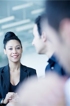 simsearch:6116-07236578,k - Young businesswoman sitting in a business meeting with colleagues Photographie de stock - Premium Libres de Droits, Code: 6116-07236557