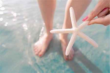 Woman holding starfish at the beach Photographie de stock - Premium Libres de Droits, Code: 6116-08805958