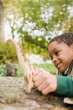 Boy playing with toy dinosaurs Photographie de stock - Premium Libres de Droits, Code: 6116-08945553