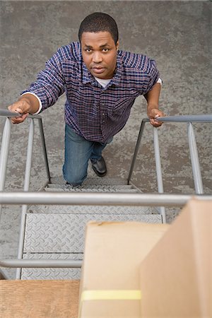 pictures of black men working in factory - Man climbing steps Stock Photo - Premium Royalty-Free, Code: 6116-08915249