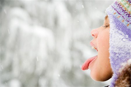 Girl in snow sticking out tongue Photographie de stock - Premium Libres de Droits, Code: 6116-08915207