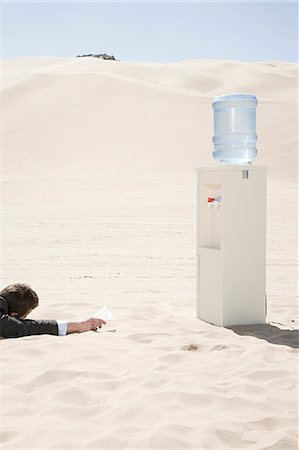 picture of thirsty man in desert - Man by water cooler in the desert Stock Photo - Premium Royalty-Free, Code: 6116-08915465