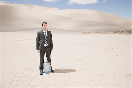 picture of thirsty man in desert - Man in desert with water bottle Stock Photo - Premium Royalty-Free, Code: 6116-08915496