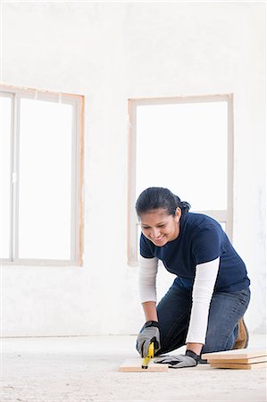 simsearch:6116-08915377,k - A female builder measuring a plank of wood Stock Photo - Premium Royalty-Free, Code: 6116-08915400