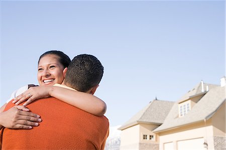 A couple hugging outside their new home Stock Photo - Premium Royalty-Free, Code: 6116-08915421