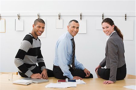 Colleagues sitting on table Stock Photo - Premium Royalty-Free, Code: 6116-08915519