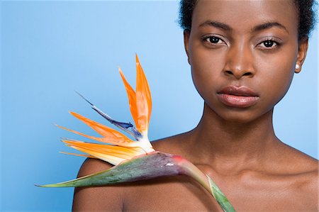 Woman holding bird of paradise flower Stock Photo - Premium Royalty-Free, Code: 6116-08915765