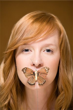 simsearch:6116-08945644,k - Butterfly covering woman's mouth Photographie de stock - Premium Libres de Droits, Code: 6116-08915766