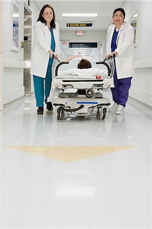 patient walking hospital halls - Doctors pushing patient in bed through corridor Foto de stock - Sin royalties Premium, Código: 6116-08915725