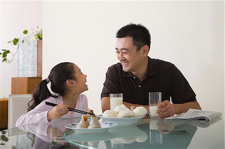 simsearch:6102-08942522,k - Father and daughter sat at a table Stock Photo - Premium Royalty-Free, Code: 6116-09013485