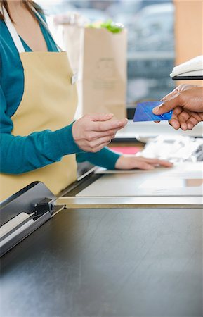 picture of a black woman at the grocery store - Customer handing a sales assistant a credit card Stock Photo - Premium Royalty-Free, Code: 6116-09013497